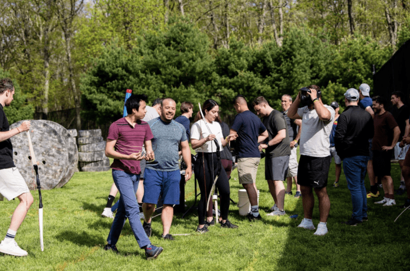 Group of people walking and talking, while preparing to play Archery Tag